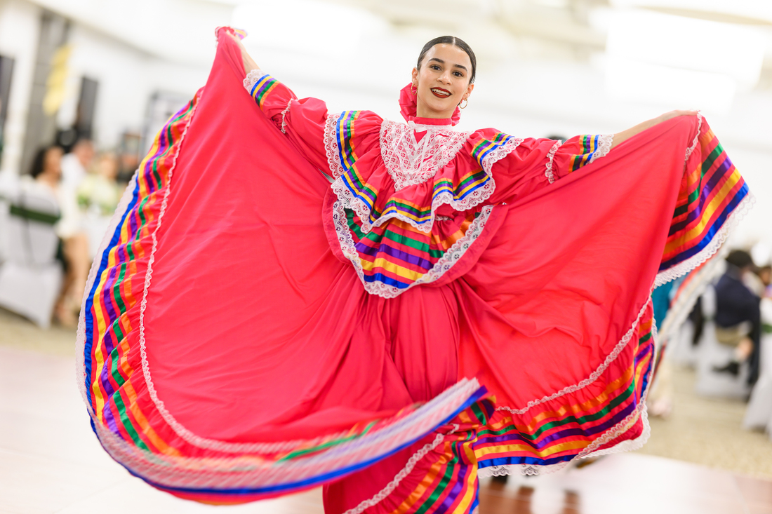 A woman wearing a traditional red dress dances