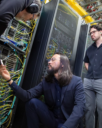 From left to right, Kelly Climber, Jose Mendoza, Daniel Maldonado Lopez, and Ismail Buliyaminu examine a super-fast InfiniBand cable in ICER's high-performance computing center.