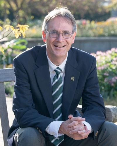 Eric L. Hegg sits on a bench looking at the camera.