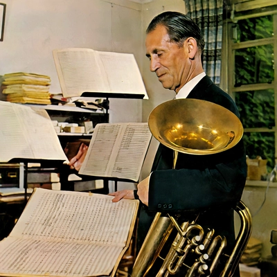 Leonard Falcone holds his tuba and inspects sheet music