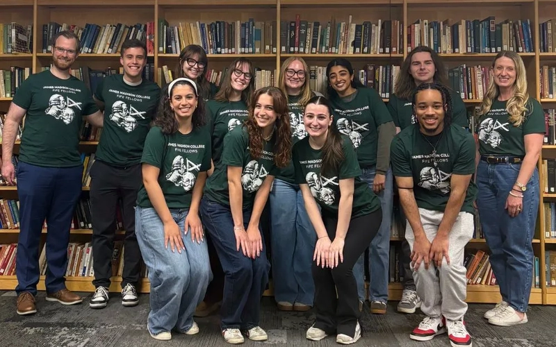 Profs. Brianne Wolf and Jordan Cash huddled in a group photo with JMC student participants of the 2025-26 Fife Fellow Program.