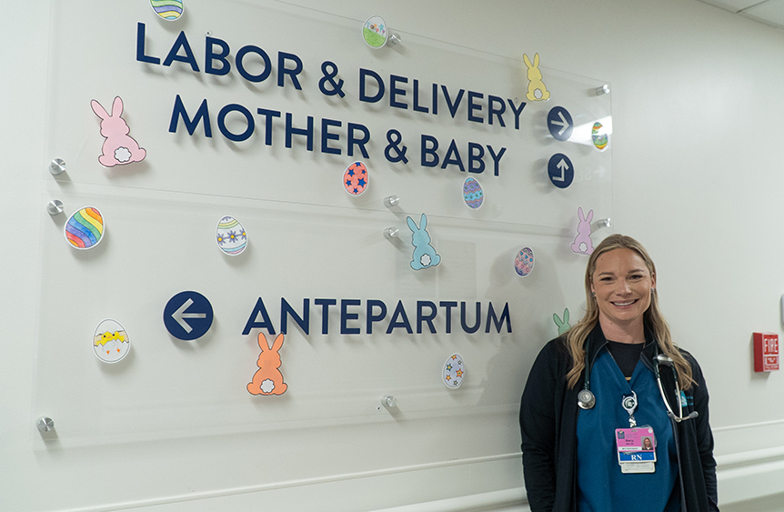 Stacy Volkers standing in front of a hospital directory sign.