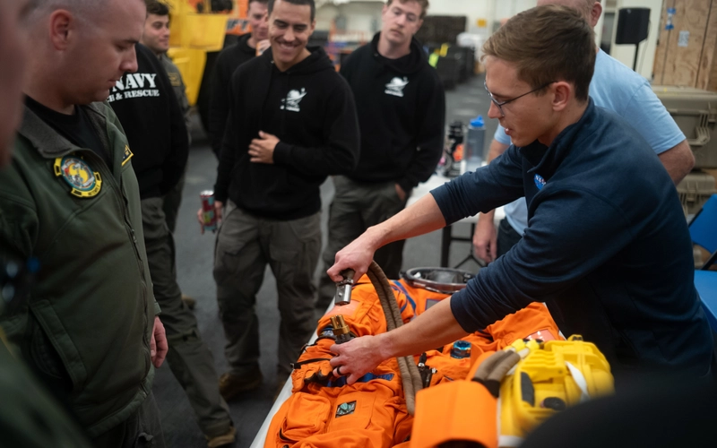 Nicholas Houghton, an Orion Crew Survival System engineer, conducts training with an Orion crew survival suit aboard the USS John P. Murtha.