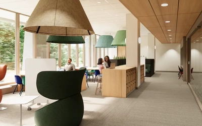 Open, modern study space with floor-to-ceiling windows and wooden work counters. Several people sit at tables and lounge chairs using laptops, with natural light and trees visible outside.