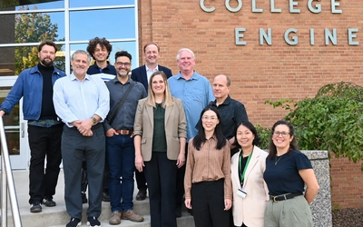 A group of people standing in front of MSU's College of Engineering building.