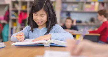 Student writing in a classroom