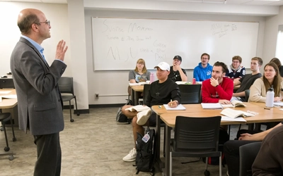 A professor instructs students in a classroom.