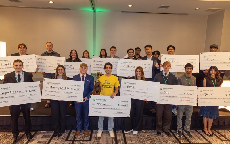 Group of students holding large checks for the Burgess New Venture Challenge.