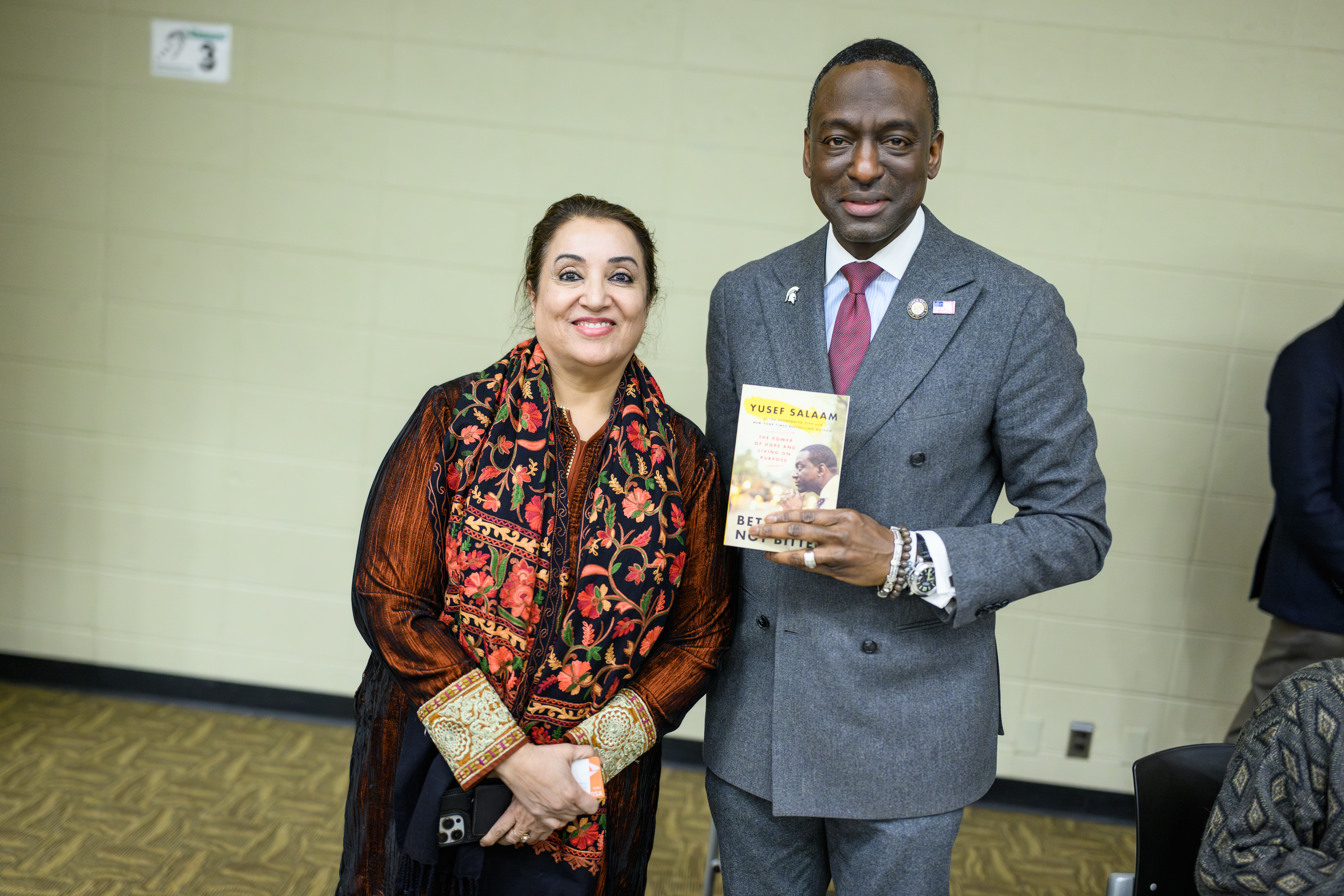 A woman poses with an author holding a book
