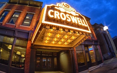 Illuminated Croswell Theatre marquee on a downtown street at dusk.