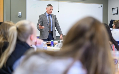 A professor talks to students in a classroom.