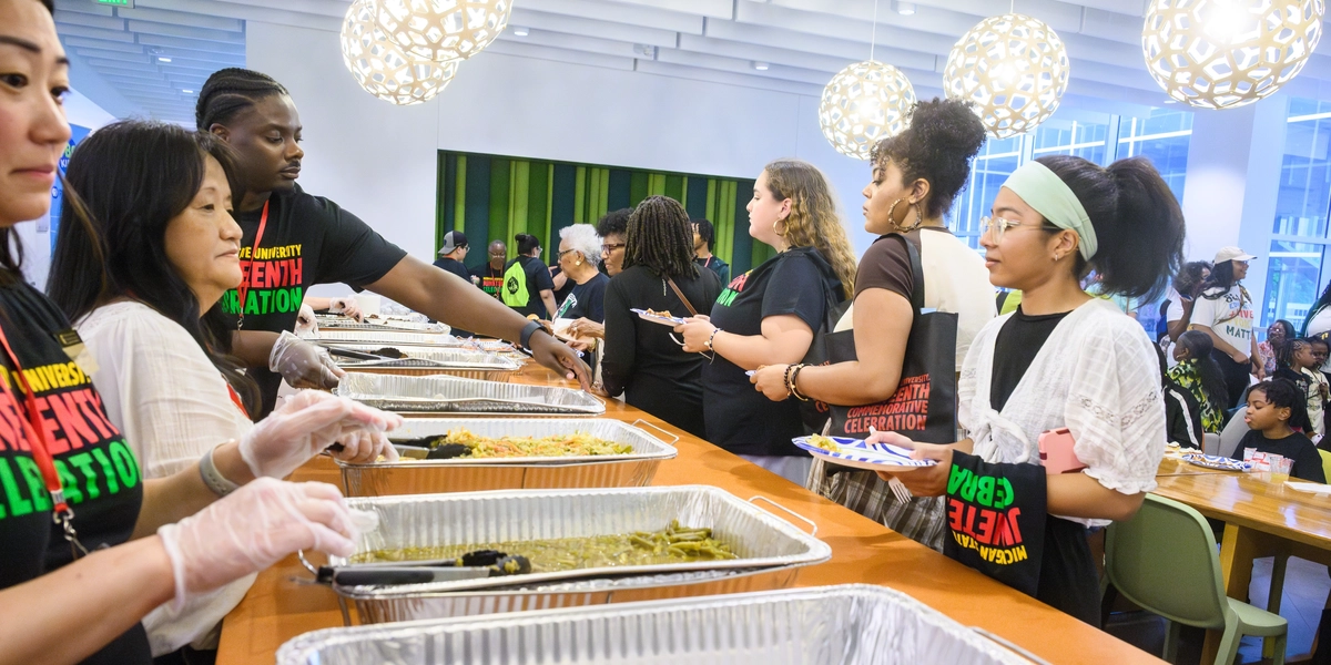 Servers stand ready to ladle food to participants