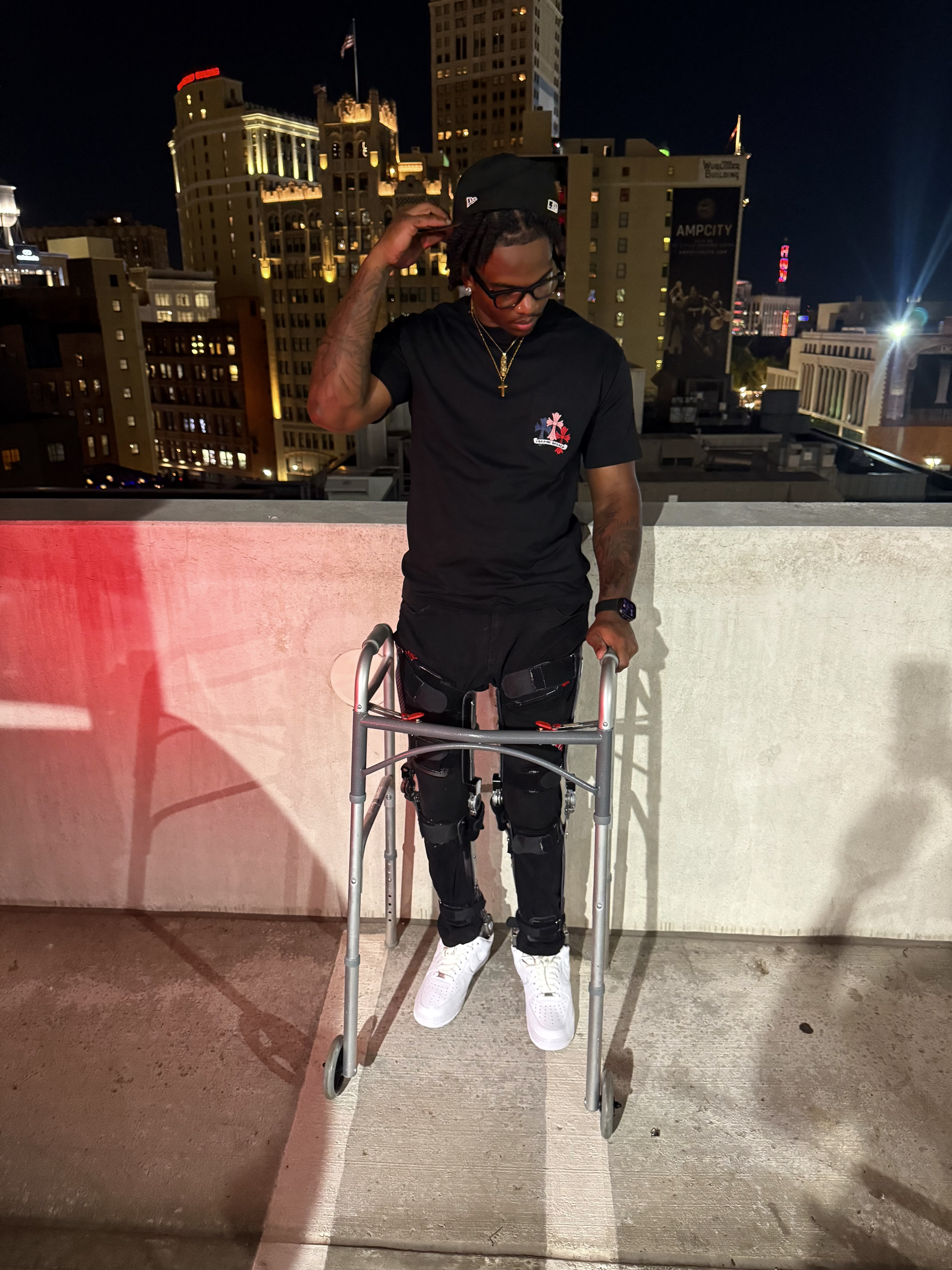 A man stands with a walker with a city backdrop