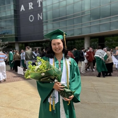 Class of 2026 graduate Rachael Lee smiling and holding flowers.