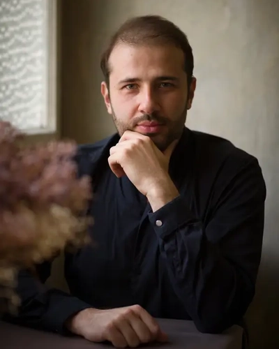 Pianist Stanislav Khristenko resting his chin on his hand.