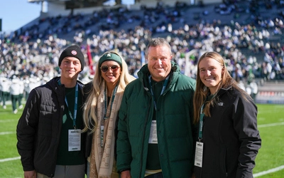 Guests pose on the field at Spartan Stadium at Michigan State University.