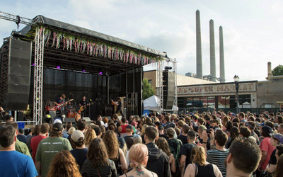 People attend an outdoor concert that is temporarily set up in a street in Lansing, Michigan.
