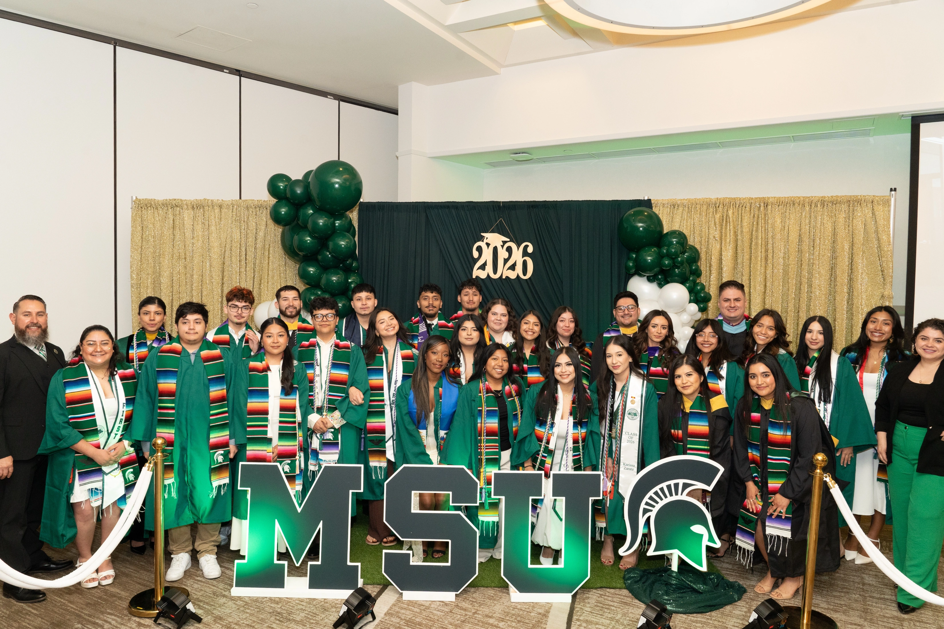 a group of college students wearing graduation caps, gowns and stoles