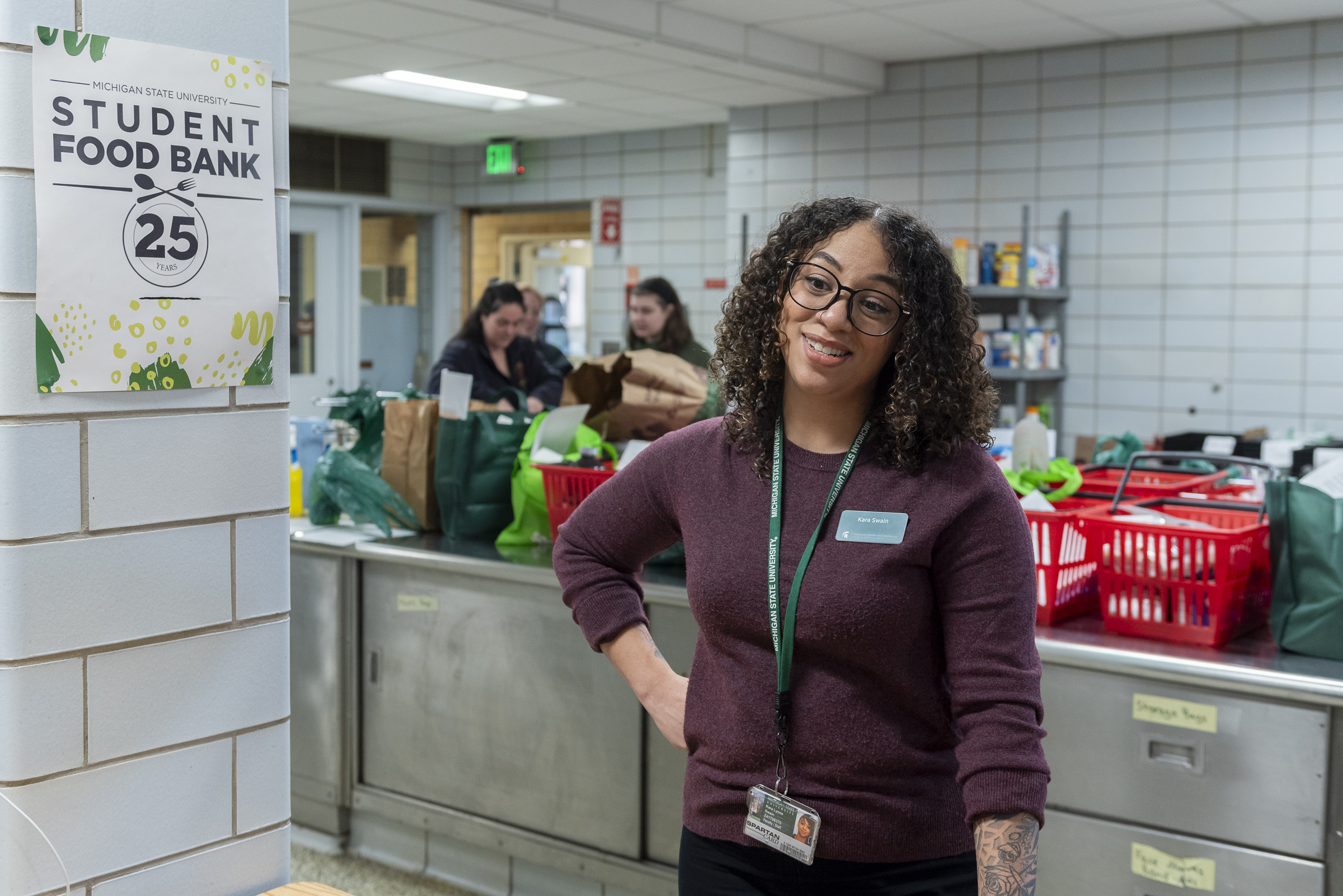 A woman stands with her hand on her hip in a food pantry