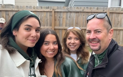 Marissa Mills, second from left, poses with her family at a tailgate, all dressed in green and white MSU apparel.