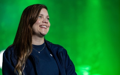 Lauren Grauer poses in front of a green light background