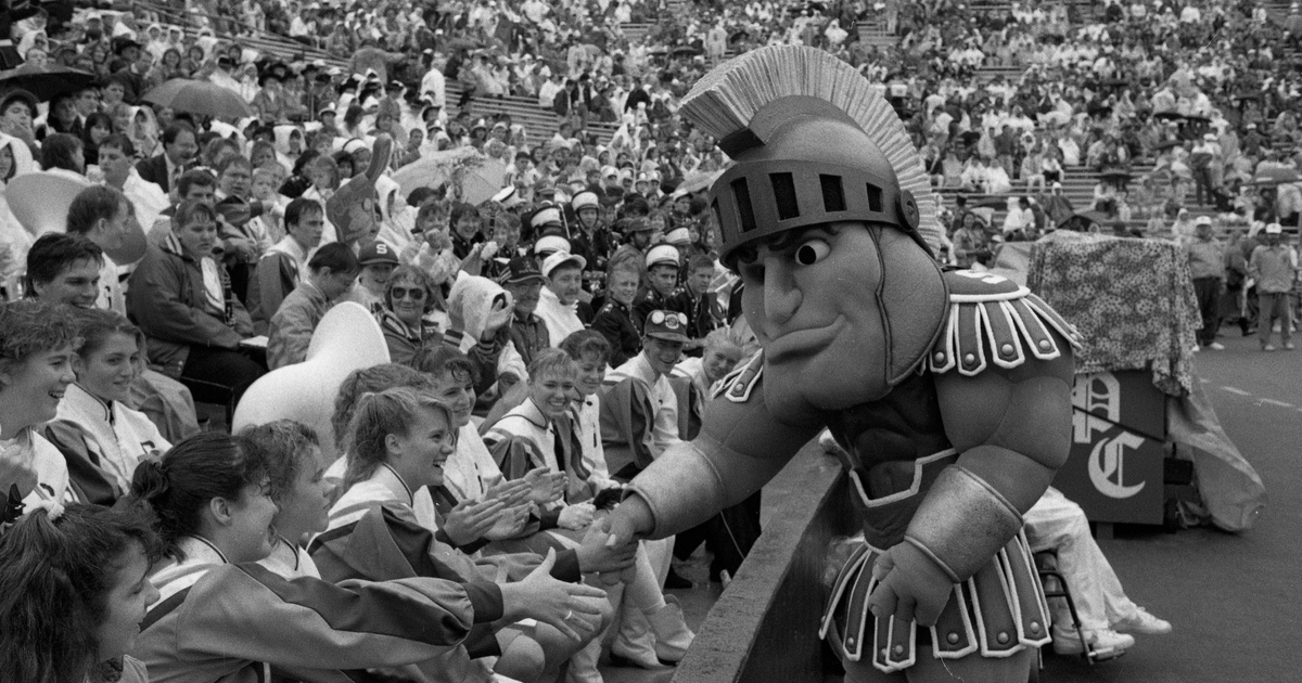 Historic image of Sparty mascot interacting with crowd at Spartan stadium