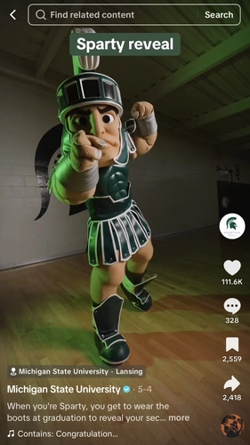 Screenshot of TikTok post from MSU showing the Sparty mascot reveal. Screenshot shows mascot standing in gymnasium pointing at camera with text on screen that says Sparty reveal