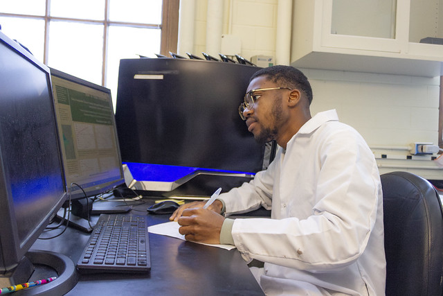 Benjamin Nketsiah at his desk writing.