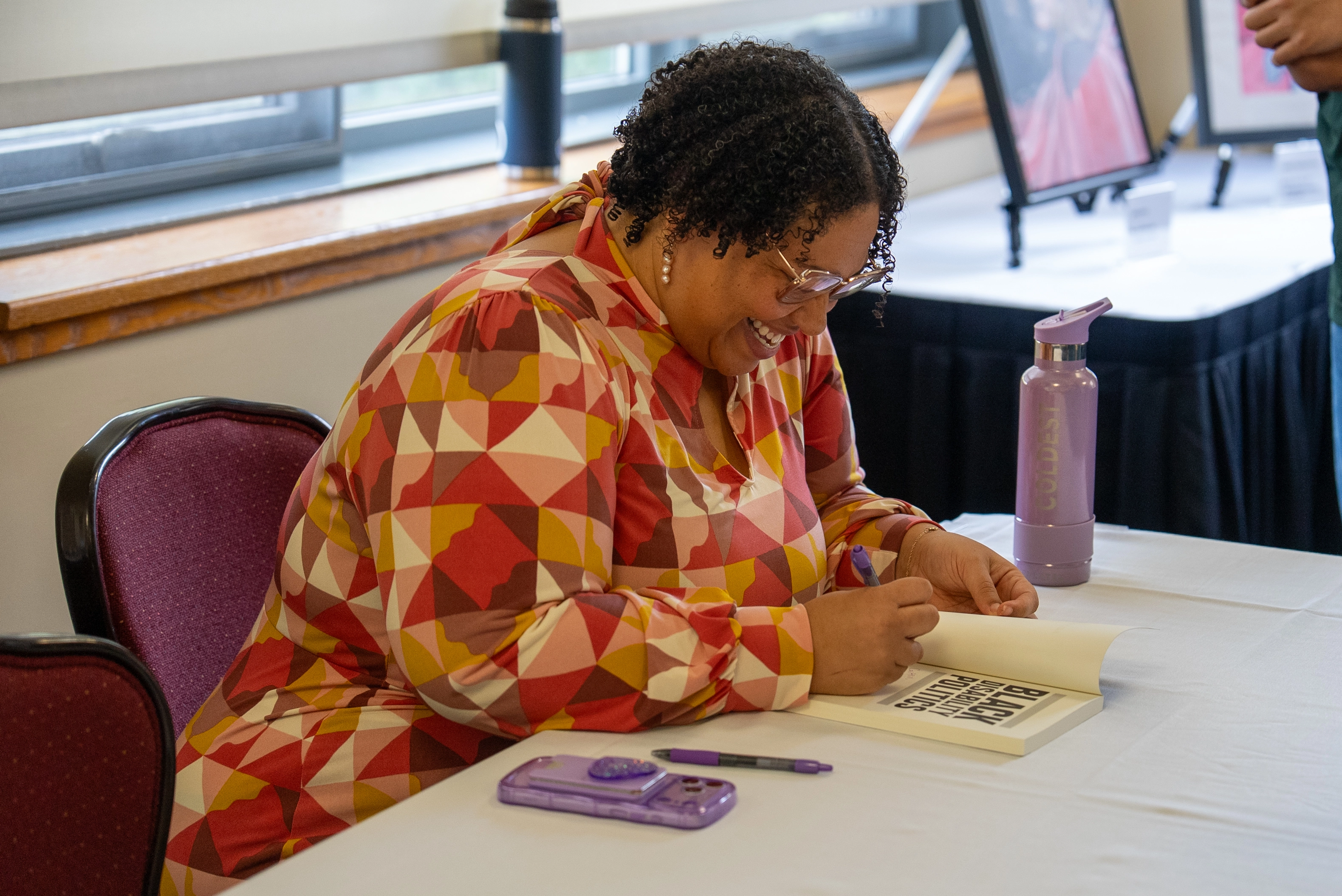 Sami Schalk signing copies of her book at the 2026 Disability Summit