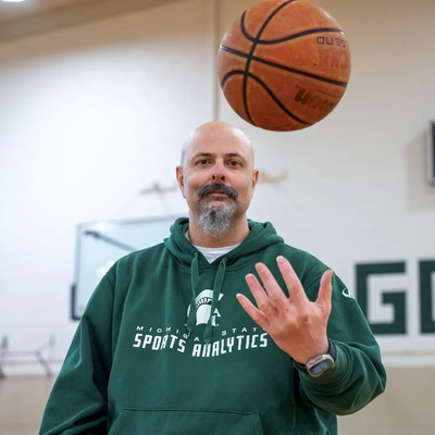 A man throwing a basketball in front of him.