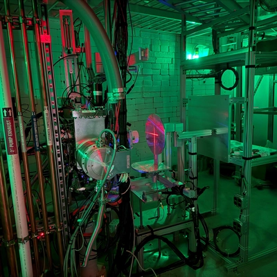 Room with green and red lights that contains a metal stand used to secure objects for testing.