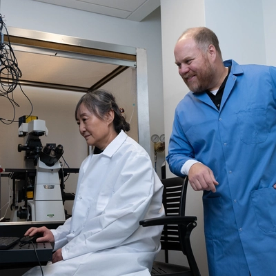 Hui Xi, associate professor of physiology, and A.J. Robison, professor of neuroscience and physiology, analyze neuron activity with electrophysiology equipment.