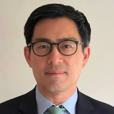 A portrait of a man in a suit wearing glasses