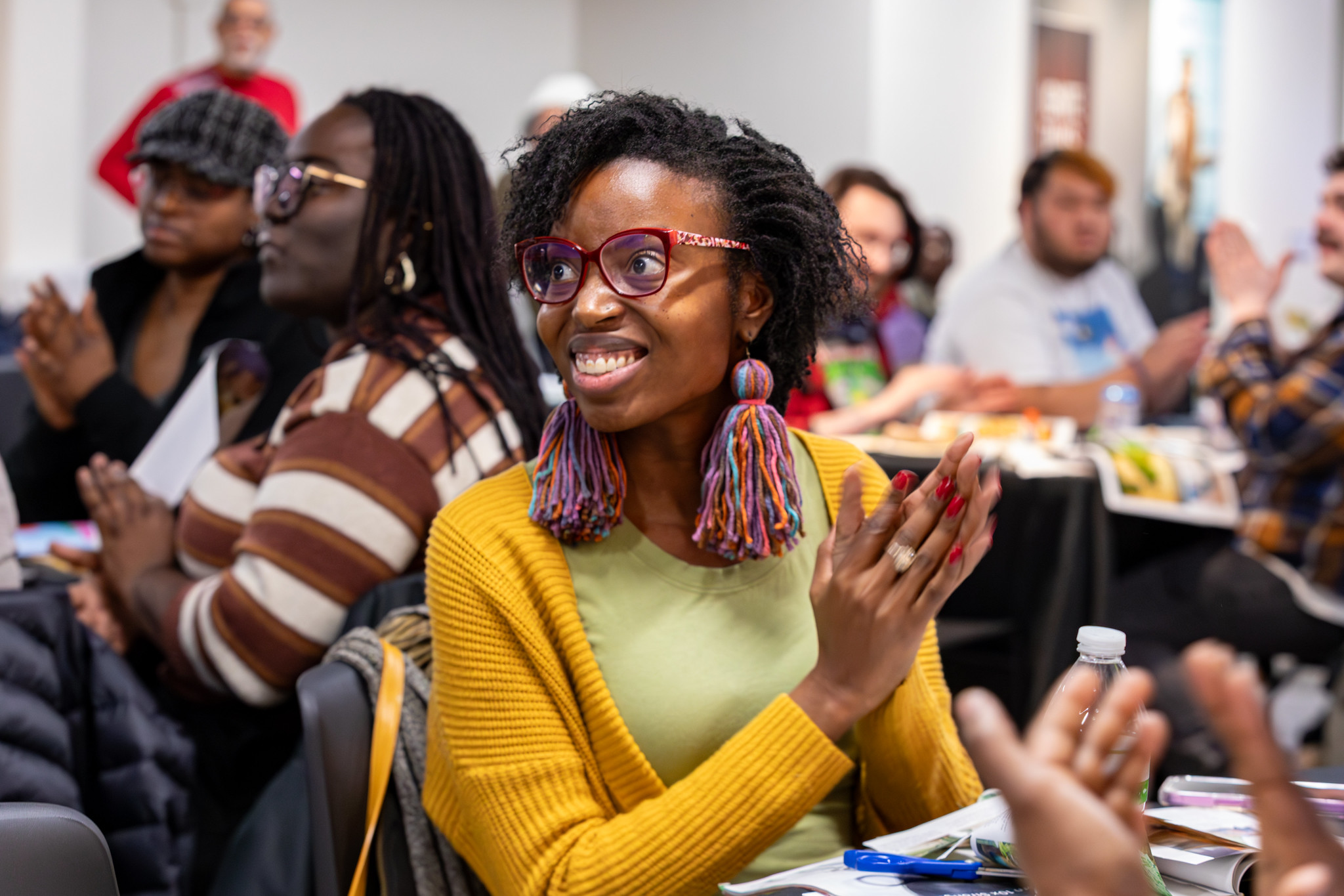 A woman claps among other attendees