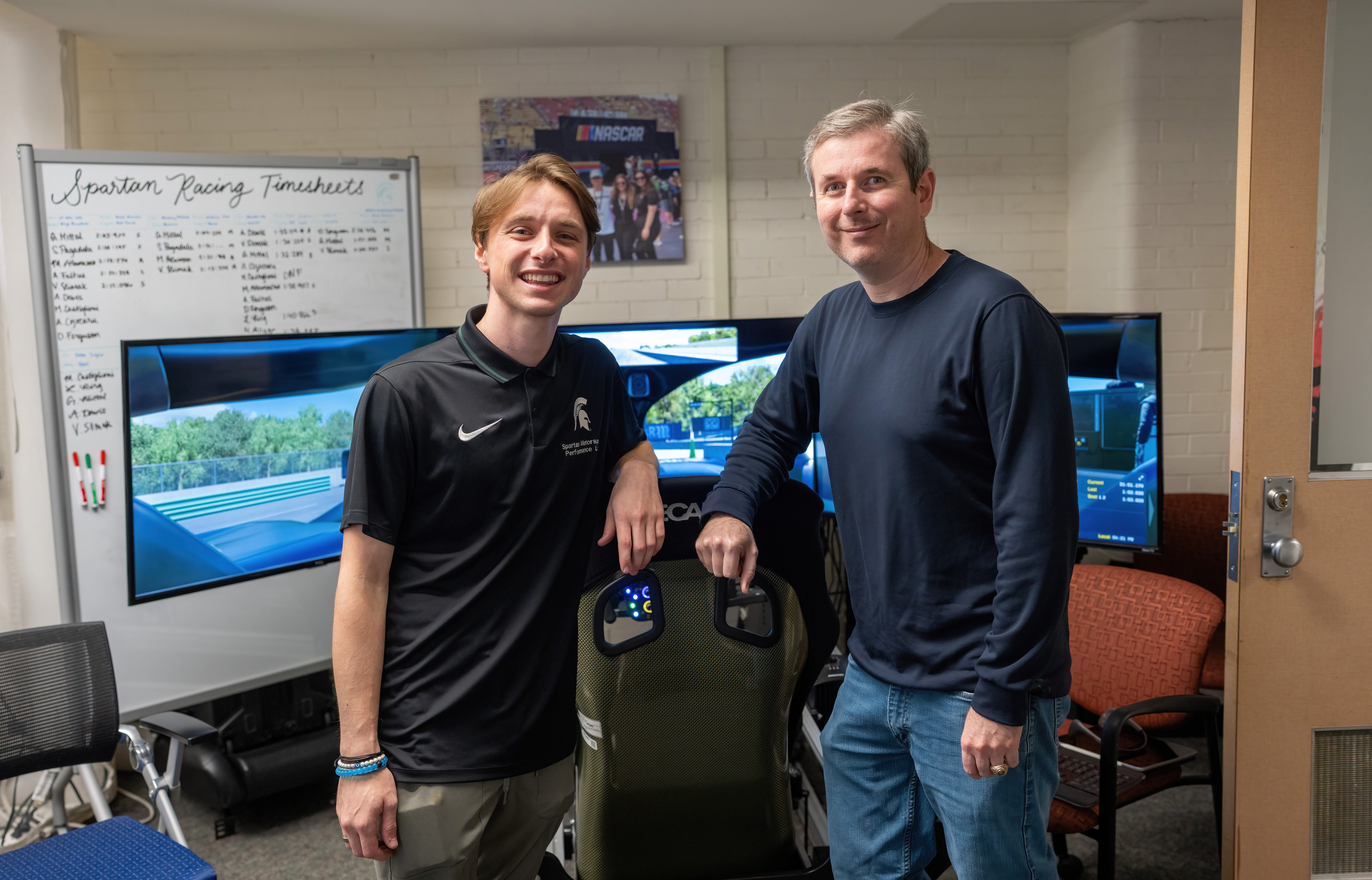 Two people standing in a motorsports lab