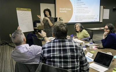 Participants engage in a collaborative small-group activity and discussion regarding implications for an aging society.