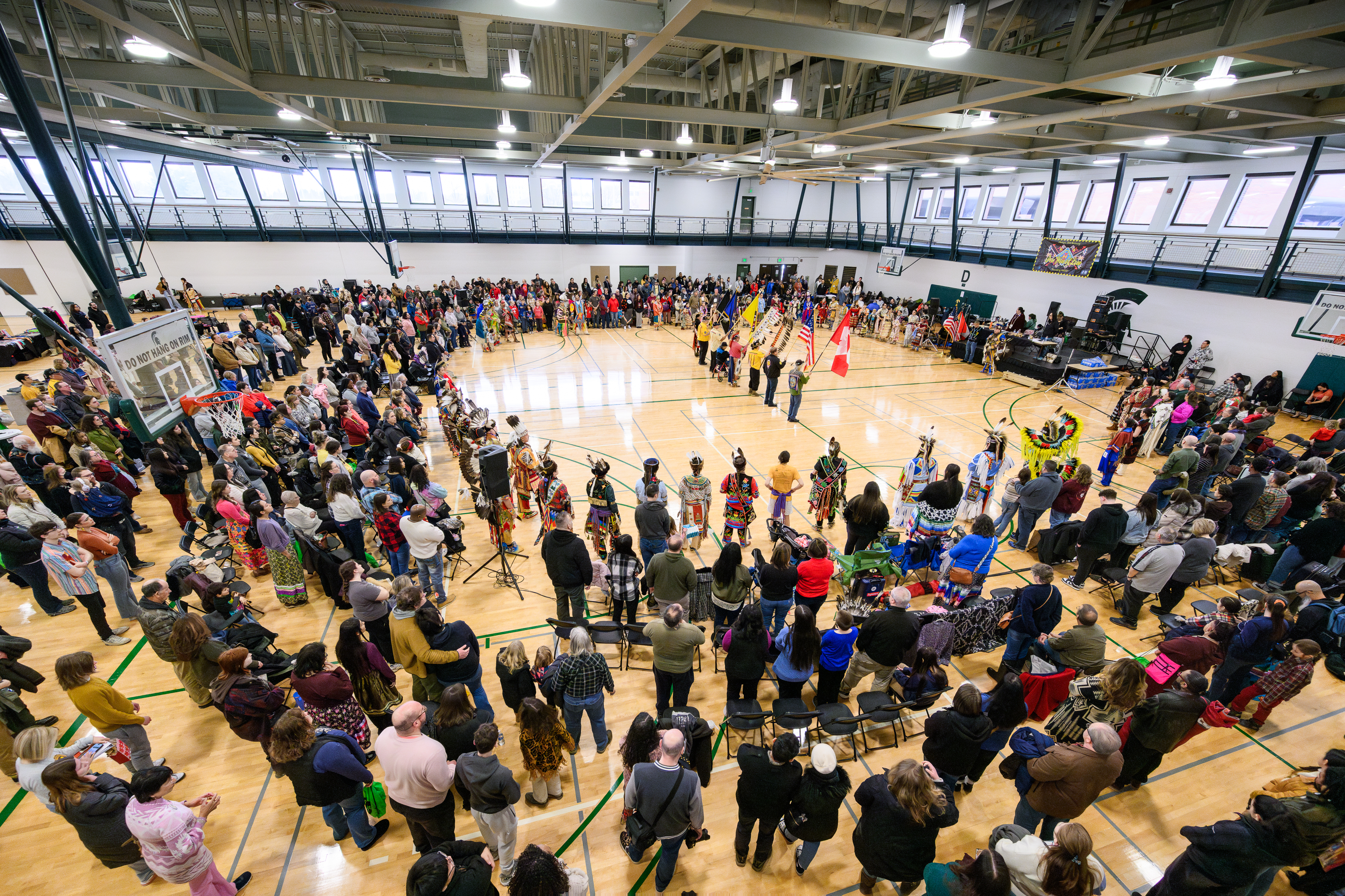 Indoor gym full of people standing around a circle