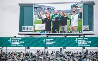 Senior leaders from both Henry Ford Health and MSU presented with the official game ball.