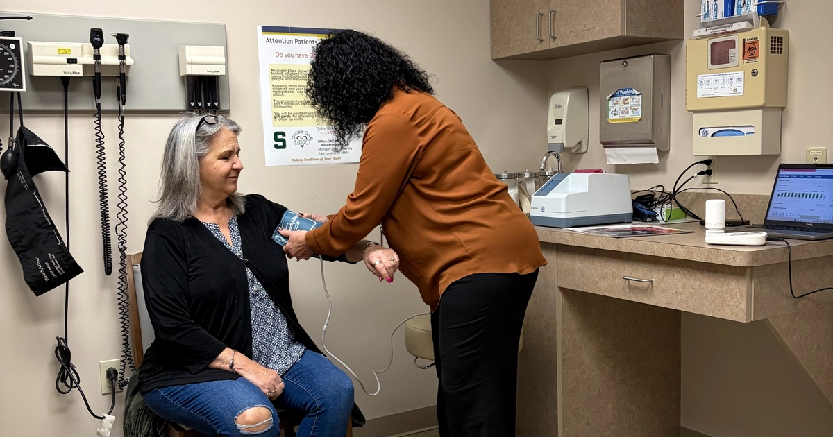 Sandy Samp taking Jane Hiske's blood pressure