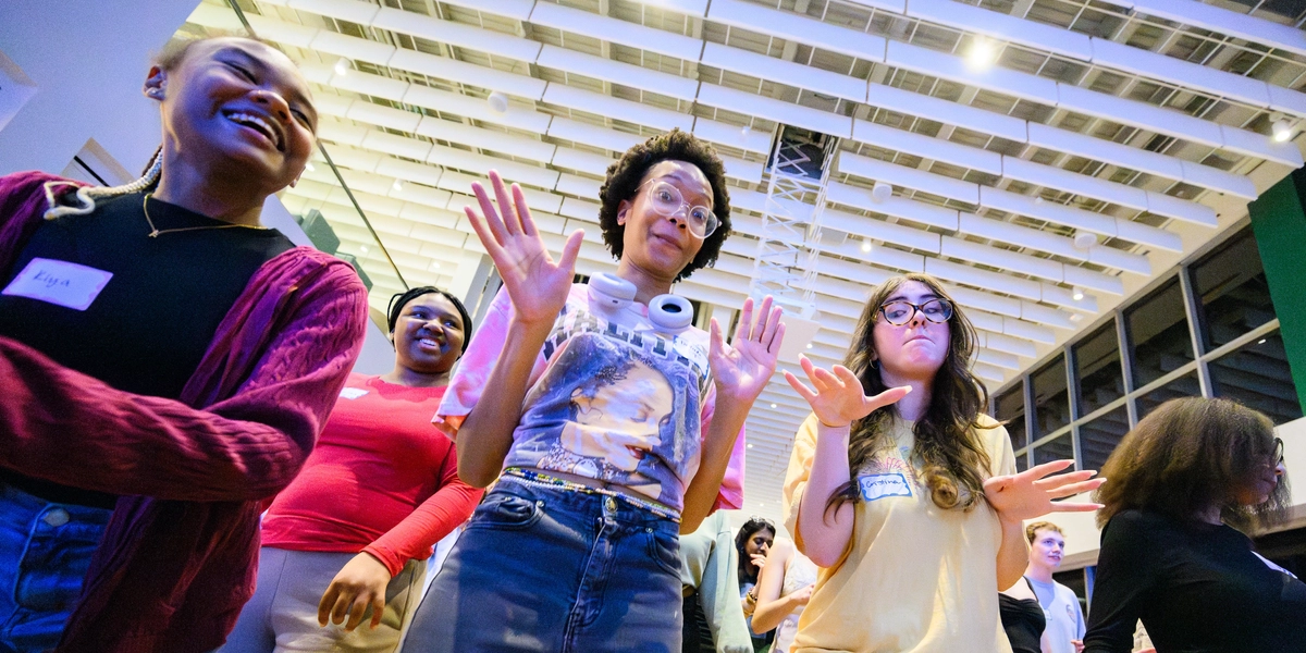 Students dancing from a low angle inside a building