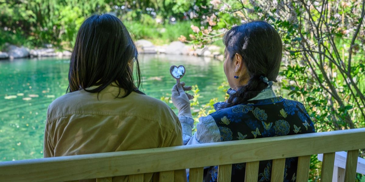 Two people sitting on bench in Radiology Healing Garden