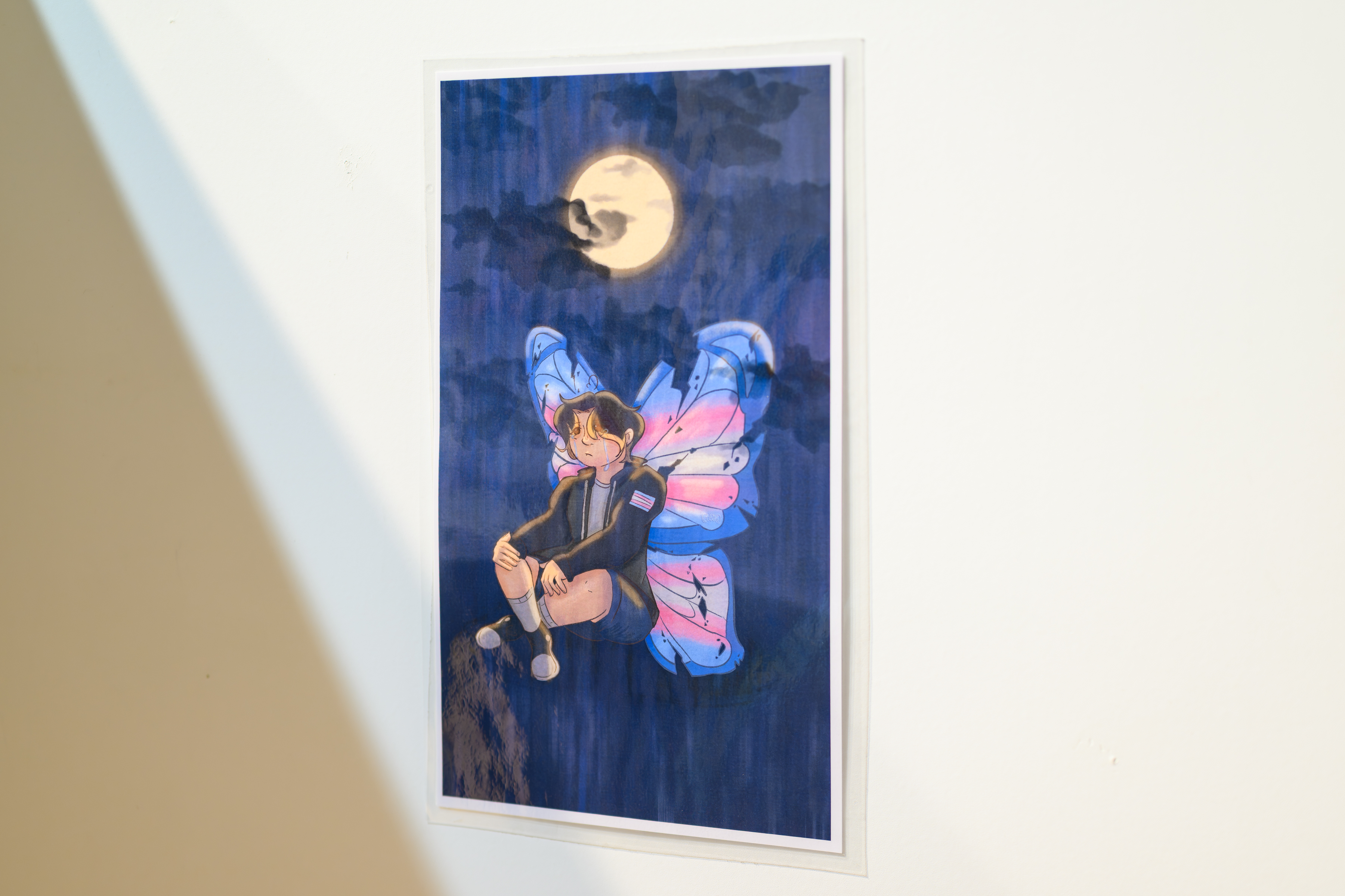 Artwork featuring a seated person with blue, pink, and white butterfly wings