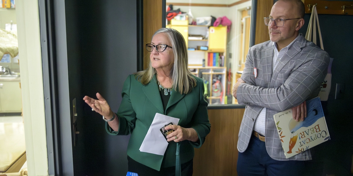 Two individuals stand outside of a child development facility.