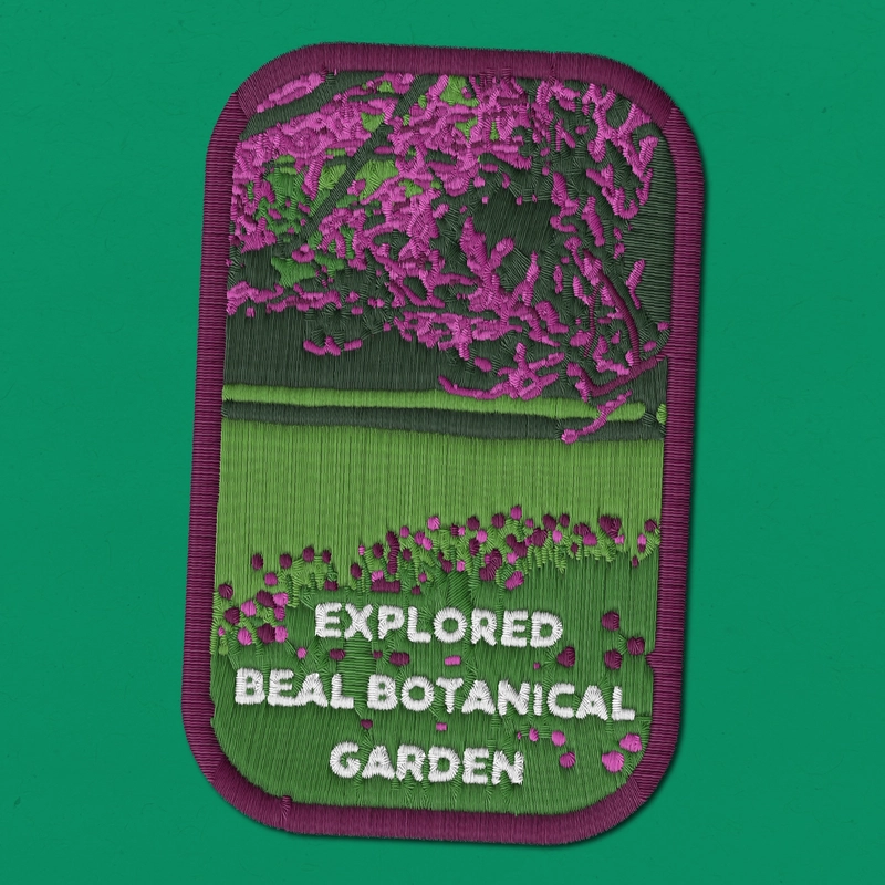 Embroidered patch with green and purple foliage with "Explored Beal Botanical Garden" with a green background.