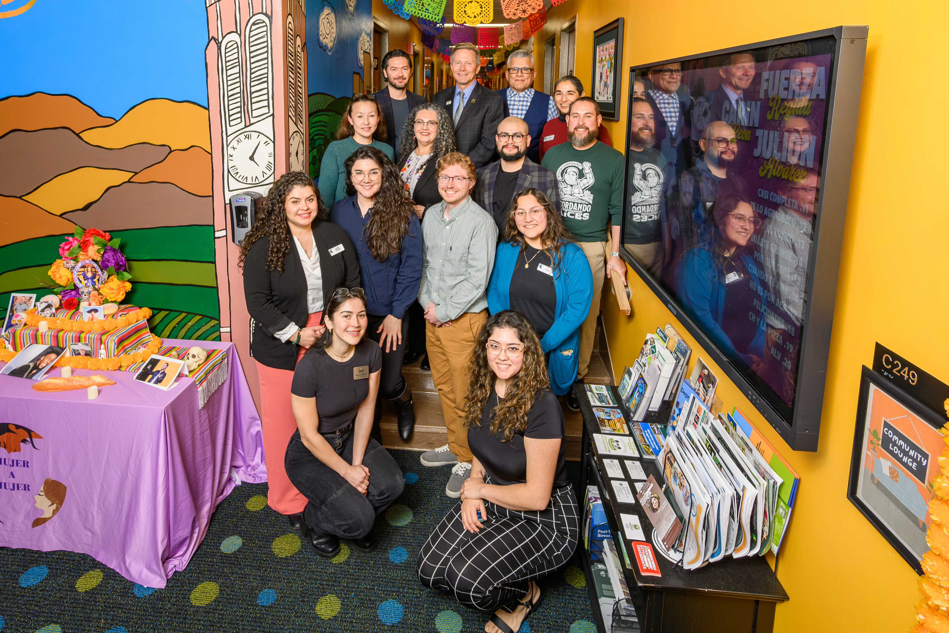 A group of staff and students in a bright colored office