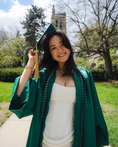 Portrait of Anastassiya Kan smiling in her MSU graduation regalia.