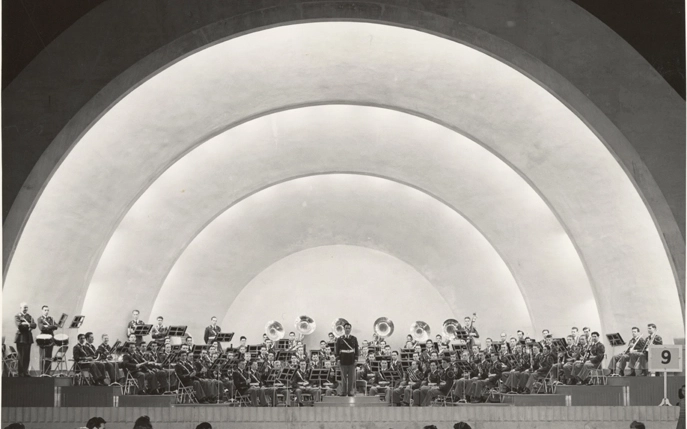 A concert band performs at a band shell with white arches in East Lansing in May 1941