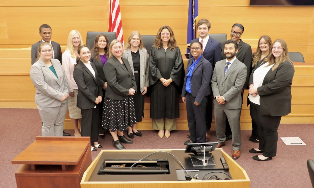 Christina Wease with a group of law students and Judge Adrienne Young standing in a courtroom setting at MSU's Low-Income Taxpayer Clinic