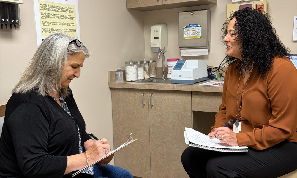 Jane Hiske talking to Sandy Samp while filling out a form