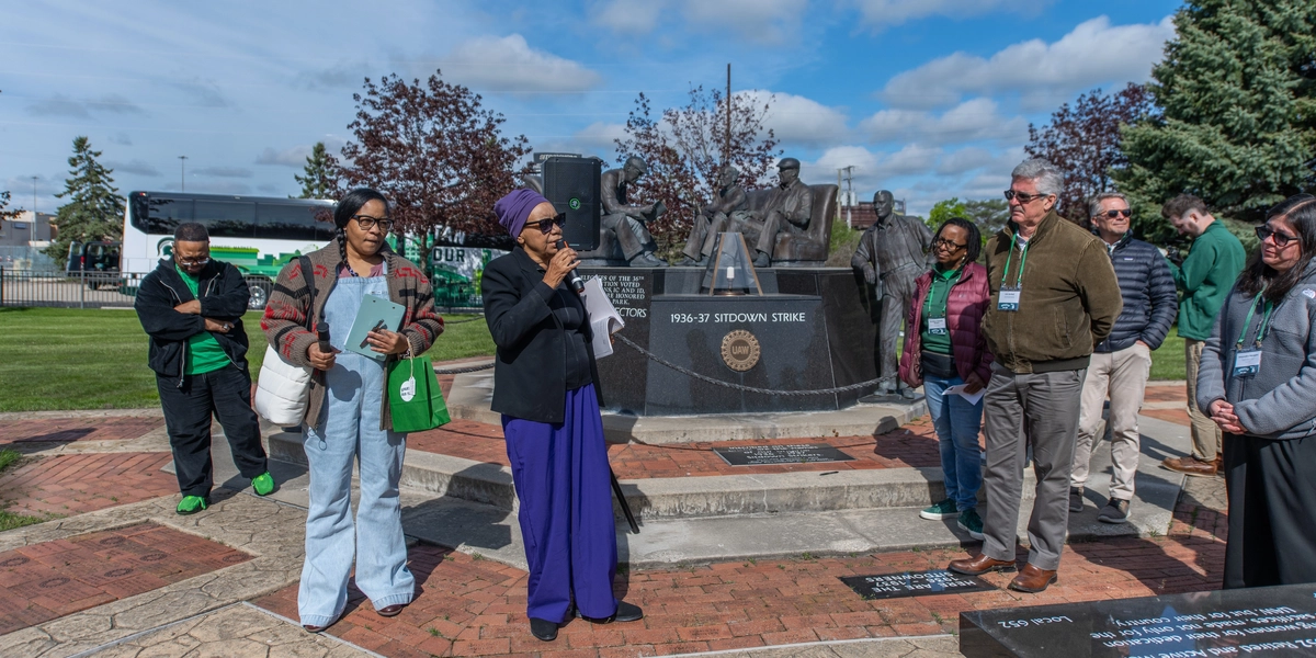 Democracy Defense League activists Claire McClinton, a retired longtime General Motors employee, and Nayyirah Shariff, share the history of Flint’s sit-down strike and its effect on organized labor in the United States at the UAS Sitdowners Monument Park